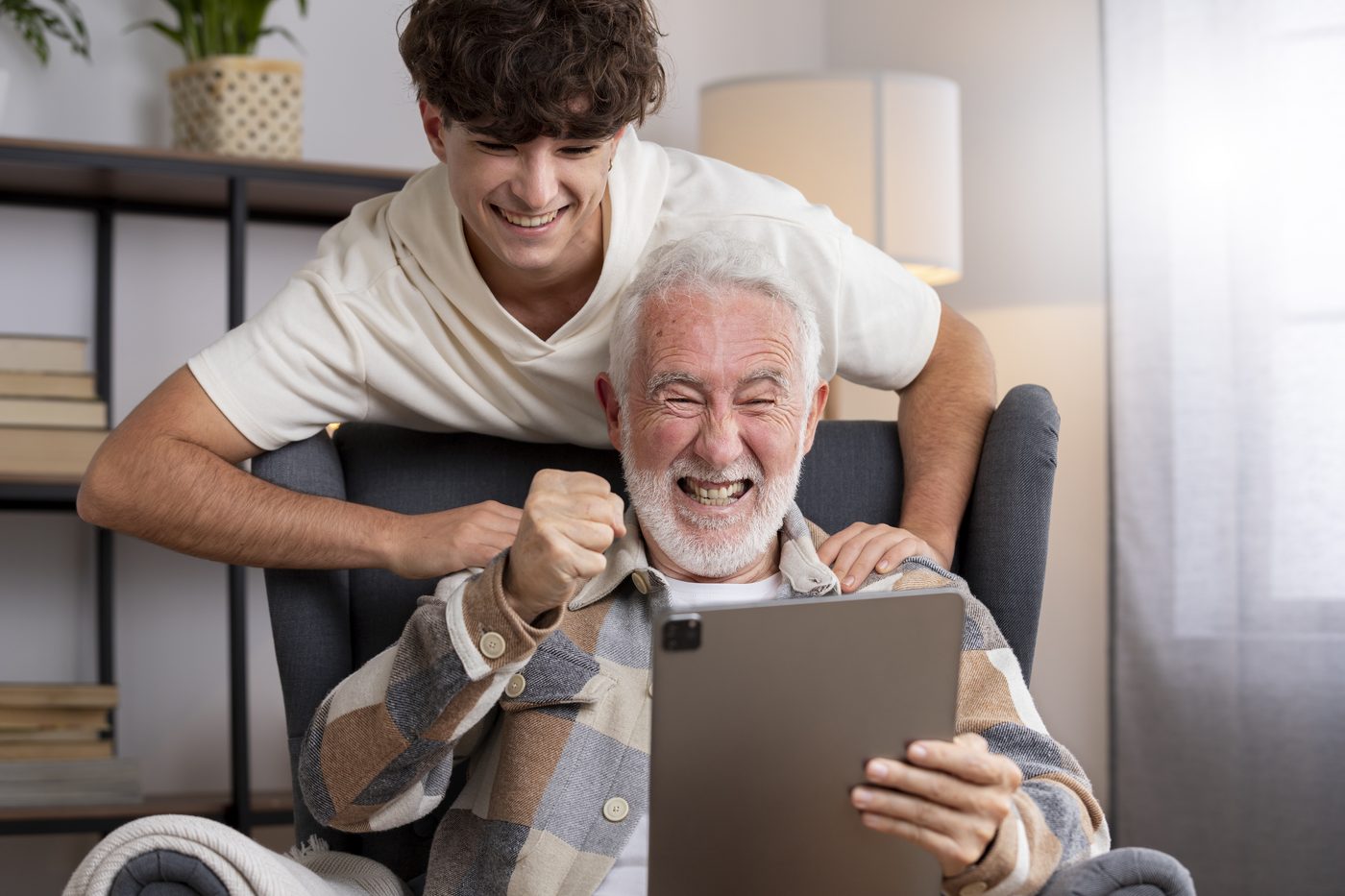 Starší muž používa tablet so svojím vnukom